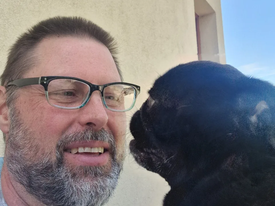Ashley Deutschmann outdoors with Freddie, one of his pugs